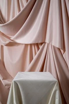 Geometric light empty podium with textile drapery on pink background, display Stock Photos