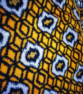 Geometric pattern features a close-up view of repeating yellow diamonds conne Stock Photos