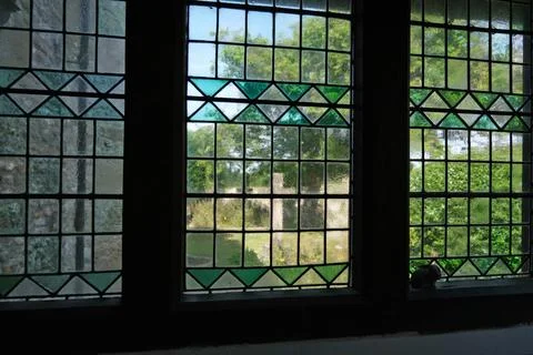 Geometric Pattern of Green and Clear Glass in Historical Church Window Stock Photos