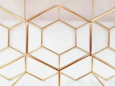 Geometric pattern of hexagons made of metal in gold color on a white backgrou Stock Photos