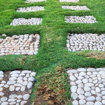 A geometric pattern is laid out with stones on the grass Stock Photos