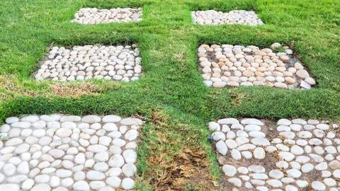 A geometric pattern is laid out with stones on the grass Stock Photos