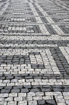A geometric pattern made by light and dark grey cobblestones. Stock Photos