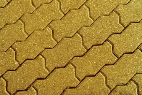 Geometric pattern made of square asphalt bricks in gold color Stock Photos