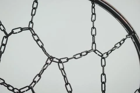 Geometric pattern of a metal chain net on a basketball hoop against an over.. Stock Photos