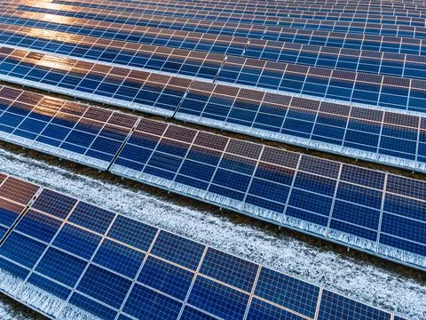 Geometric Pattern of Solar Panels with Snow from Aerial View Stock Photos