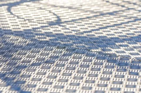 Geometric pattern on textured metal surface with light and shadow interplay Foto stock