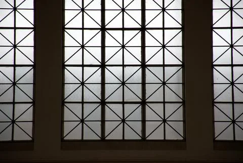 Geometric patterned glass window with lattice symmetry and soft light shadows Stock-Fotos