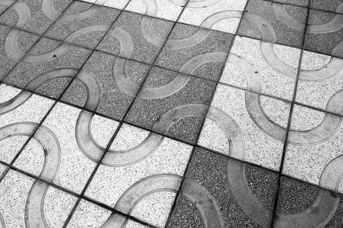 Geometric patterned tile flooring arranged in a curving, wave-like design. th Stock Photos