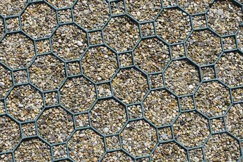Geometric plastic ground grid filled with gravel texture Stock Photos
