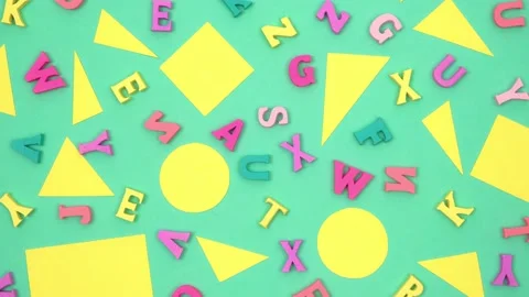 Geometric shapes and letters randomly lie on a rotating green background. 4k. Stock Footage 204827418