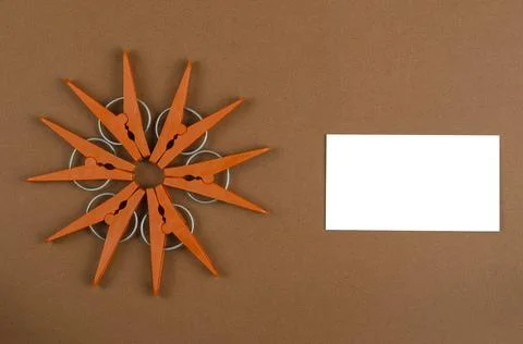 Geometric star shape made from brown plastic clothespins and white blank busi Stock Photos