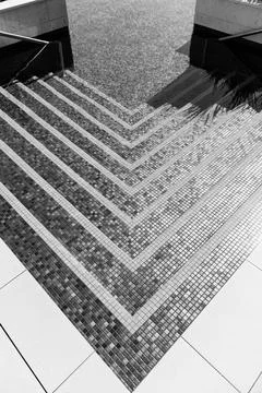 Geometric tiled steps descending into pool Stock Photos