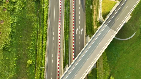 Geometric top-down aerial view of a white van driving under a highway overpass Stock Footage 318155960