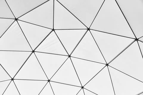Geometric triangles form abstract wall pattern in soft white light Stock Photos
