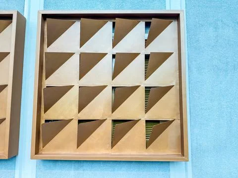 Geometric ventilation panel with triangular patterns on a blue wall. Urban de Stock Photos