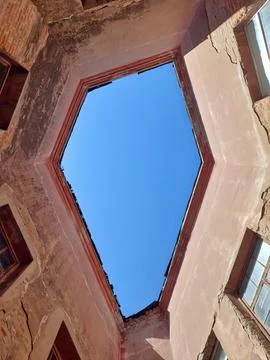 Geometric view looking up at blue sky through historical atrium Stock Photos