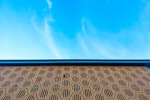Geometric wall pattern with hexagonal shapes and ventilation holes against .. Stock Photos