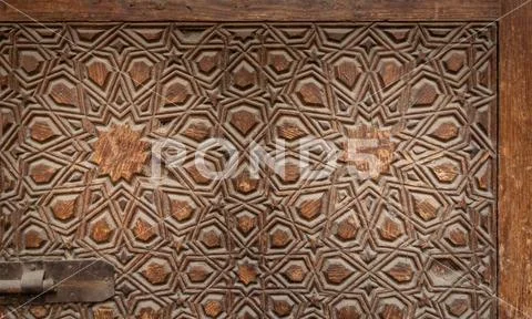 Geometrical engraved decorations of an aged wooden ornate door leaf Stock Photos