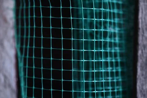Geometrically distorted texture grid. green grid background. Selective focus. Stock Photos
