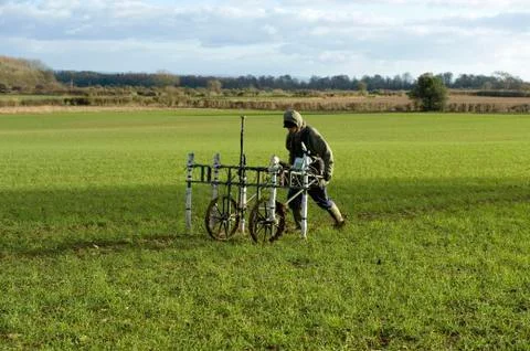 A geophysicist pushing a trolley with ground mapping sensors, creating a Stock Photos