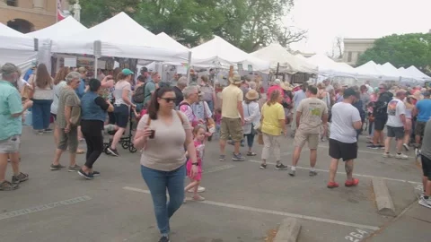 Georgetown TX crowds walking past festival vendor tents 4k Stock Footage 184749562