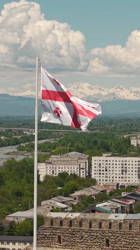 Georgian Flag Waving over Gori Cityscape and Caucasus Mountains 動画素材 336254016