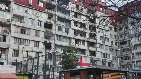 Georgian flag waving on a soviet-era apartment building in batumi Stock Footage 333499103