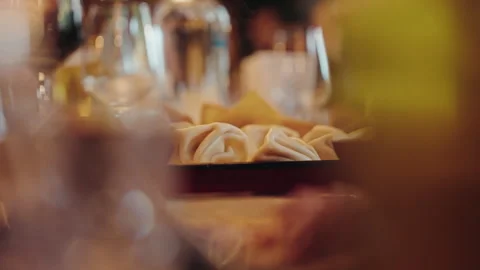 Georgian khinkali dumplings through soft foreground bokeh Stock Footage 346745736