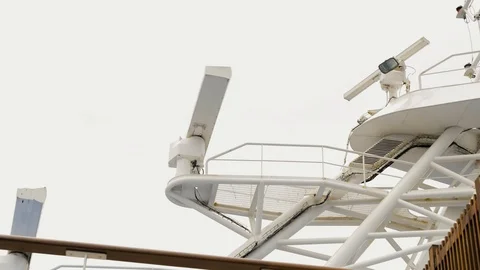 Geospatial data technology spins atop a large ship under a cloudy sky Stock Footage 116979936