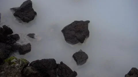 Geothermal complex Blue Lagoon. Black stones on the shores of a mineral lake Stock Footage 130454776