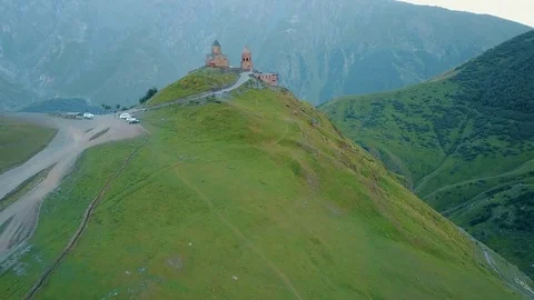 Gergeti Trinity Church, Tsminda Sameba Gergeti Georgia Europe mountains cows Stock Footage 81380164