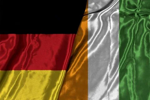 German And Ivory Coast Flags Draped Together On Silk Fabric Symbolizing Friendsh Stock Photos