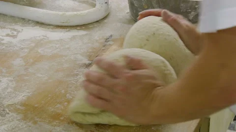 German baker kneading two breads side view Stock Footage 56341269