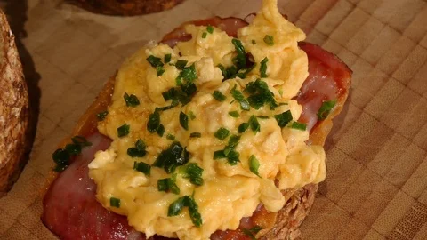 German bread: emmer amelcorn wheat bread with ham and scrambled eggs topview Stock Footage 84885690