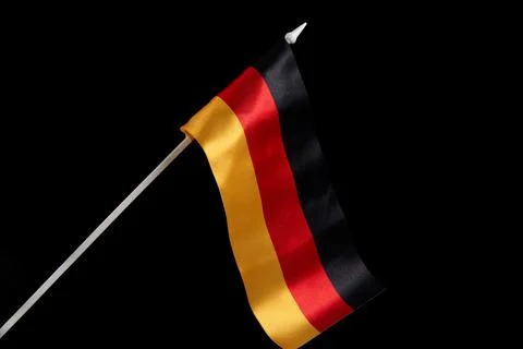 The German flag on a black background develops and flies in the wind Foto stock