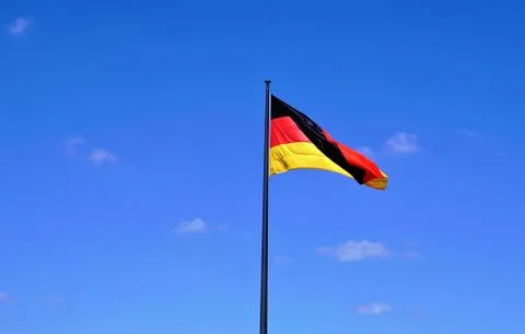 German flag in front of blue sky Stock Photos