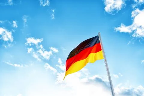 A German flag in front of clouds in blue sky Stock Photos