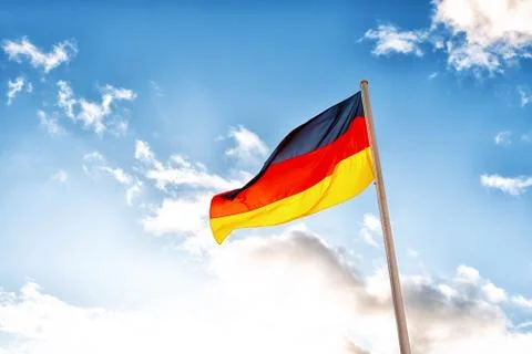 A German flag in front of clouds in blue sky Stock Photos