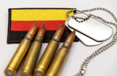 German flag patch with bullets and military dog tags on white surface Stock Photos