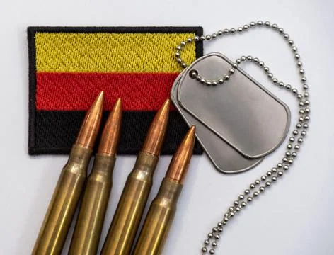 German flag patch with rifle bullets and metal dog tags on gray background .. Stock Photos
