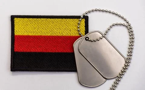 German flag patch with silver dog tags on gray background close up Foto stock