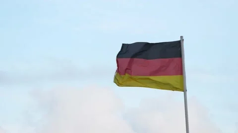German flag waving in wind on blue sky background Stock Footage 206816593