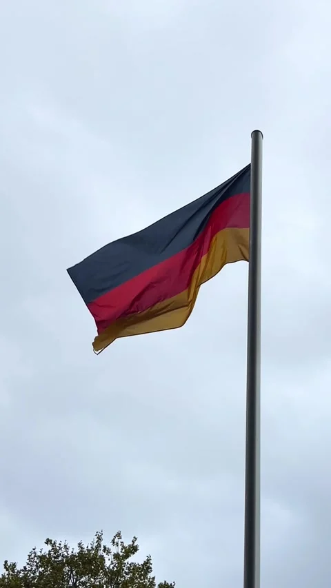 German flag waving in the wind on a cloudy day at a public location Stock Footage 329320123