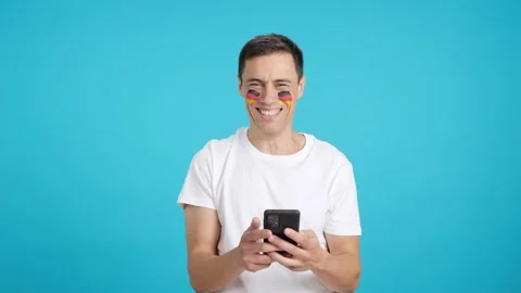 German man looking at his mobile smiling and showing it. 動画素材 252484656