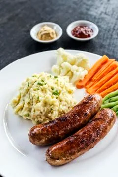 German sausage with mashed potato and vegetables meal Stock Photos
