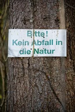 German sign on a tree asking for no litter in nature Stock Photos