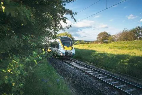 German train traveling through spring countryside scenery Stock Photos
