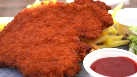 German Wiener schnitzel ( Schnitzel mit Pommes Frites ) at beer hall in Germany Stock Footage 278621946