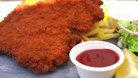 German Wiener schnitzel ( Schnitzel mit Pommes Frites ) at beer hall in Germany Stock Footage 278621967